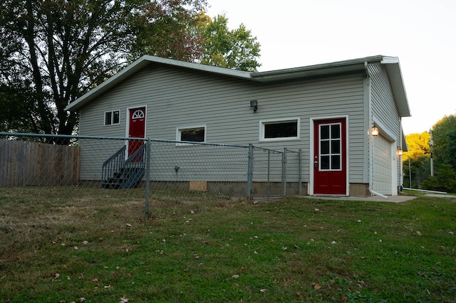 rear view of property with a lawn and a garage