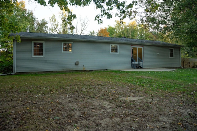 rear view of house with a patio and a yard