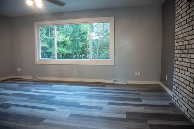 empty room with ceiling fan and dark wood-type flooring