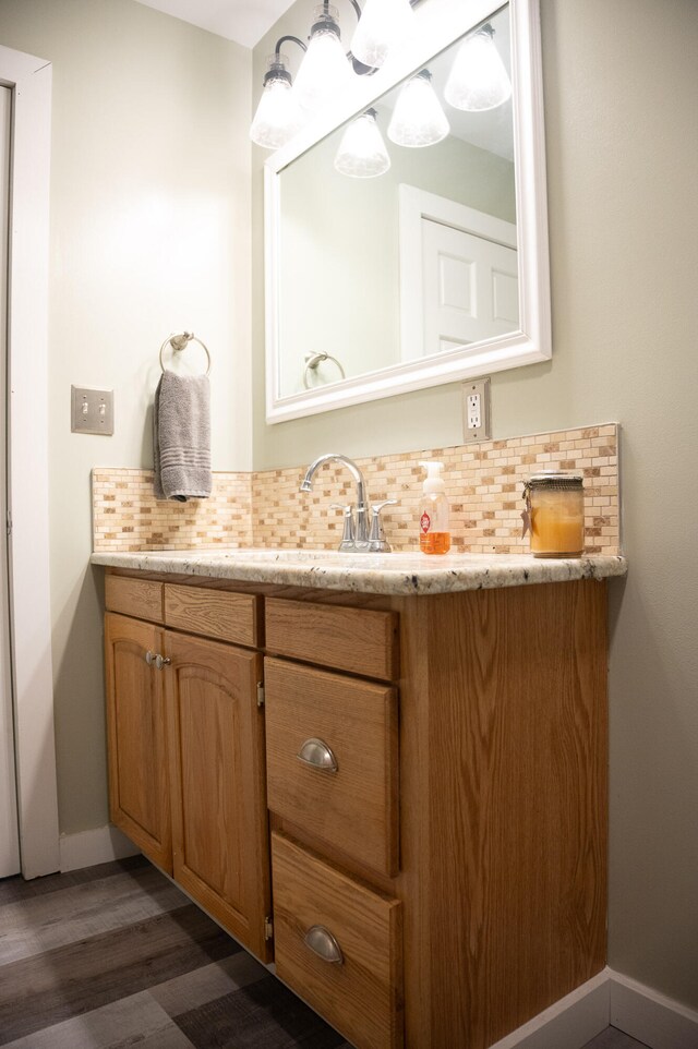 bathroom featuring backsplash, hardwood / wood-style flooring, and vanity