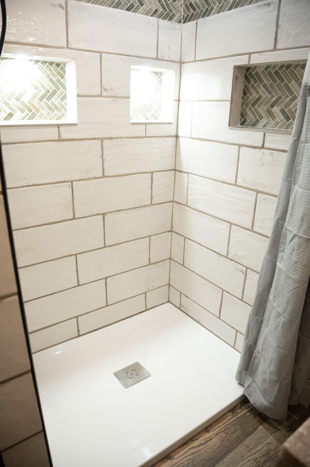 bathroom featuring walk in shower and hardwood / wood-style floors