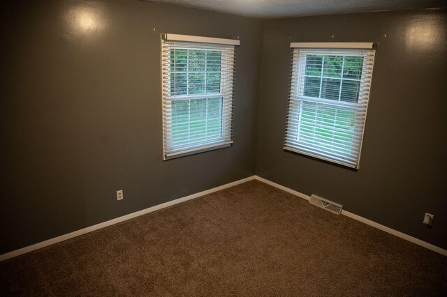 unfurnished room with a textured ceiling and carpet flooring