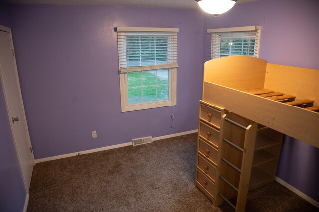 unfurnished bedroom featuring dark carpet