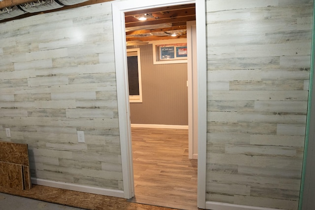 corridor with hardwood / wood-style floors and wooden walls