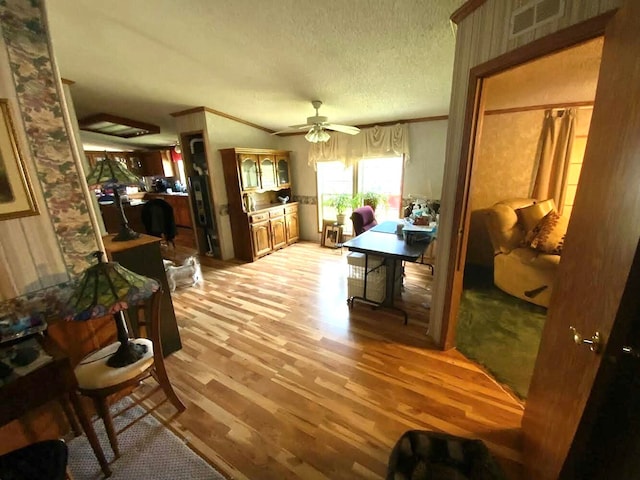 interior space with crown molding, light wood-type flooring, and a textured ceiling