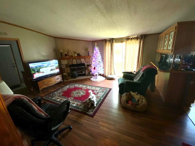 living room featuring a textured ceiling, a fireplace, dark hardwood / wood-style floors, and ornamental molding