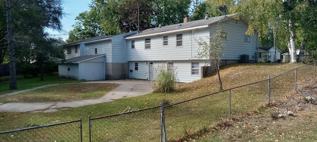 back of property with central AC and a lawn