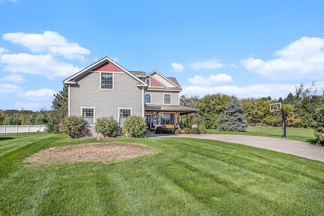 view of front of house featuring a front lawn, basketball court, and covered porch