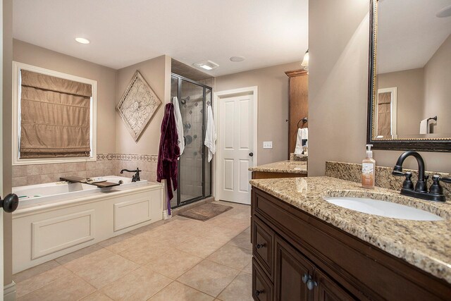 bathroom with tile patterned flooring, vanity, and plus walk in shower