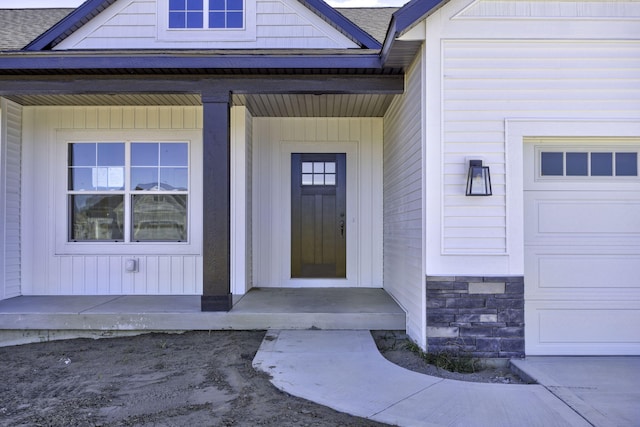 entrance to property featuring a porch and a garage