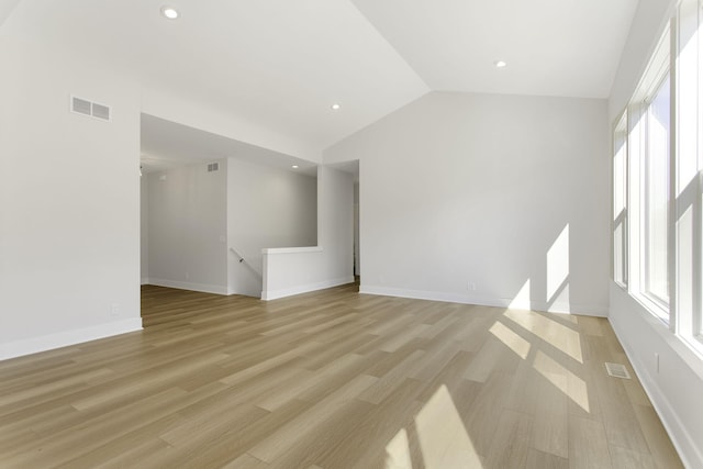 unfurnished living room featuring lofted ceiling and light hardwood / wood-style flooring