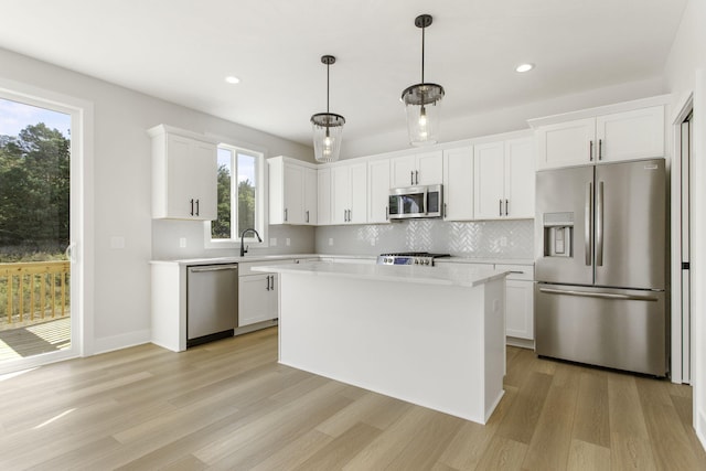 kitchen featuring stainless steel appliances, plenty of natural light, and white cabinets