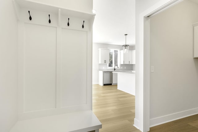 mudroom with light hardwood / wood-style floors and sink