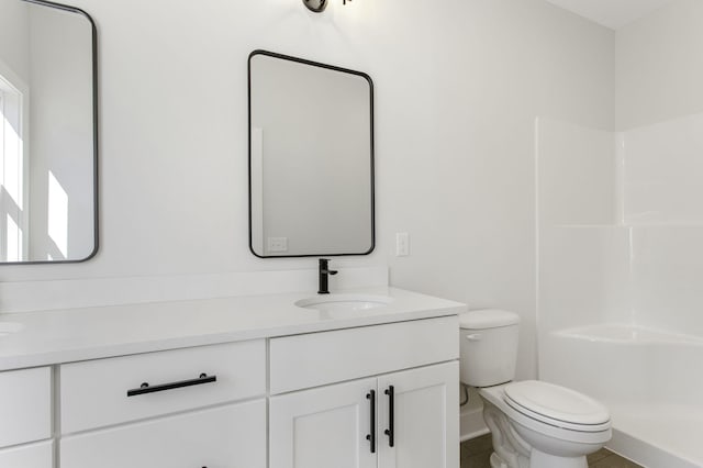 bathroom featuring tile patterned flooring, vanity, walk in shower, and toilet