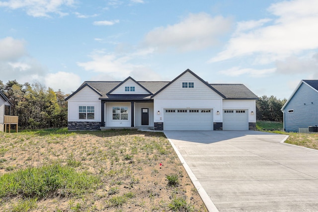 9530 Shoreway Dr, West Olive, MI 49460 - view of front of house with stone siding, an attached garage, driveway, and a shingled roof