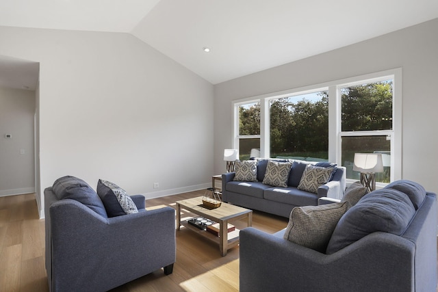 9530 Shoreway Dr, West Olive, MI 49460 - living area featuring vaulted ceiling, baseboards, and light wood-style floors