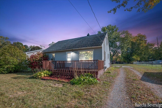 view of front of property featuring a wooden deck and a yard