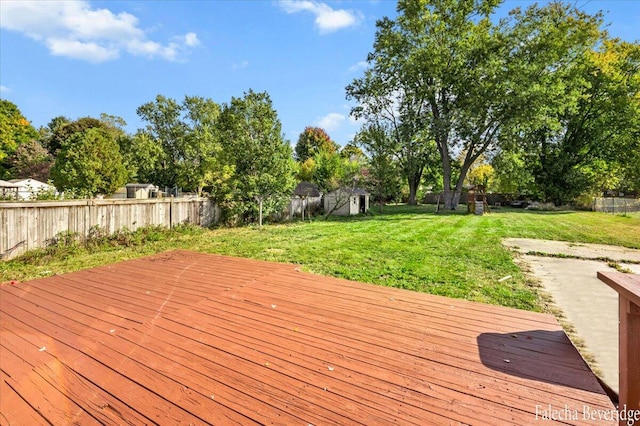 deck with a shed and a lawn