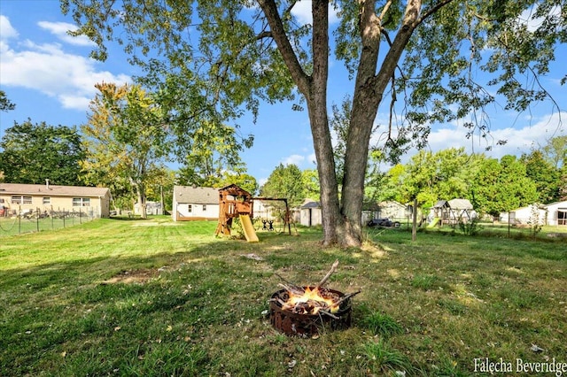 view of yard featuring a playground and a fire pit