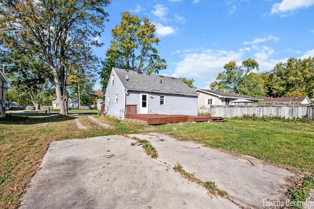 rear view of property featuring a yard and a deck