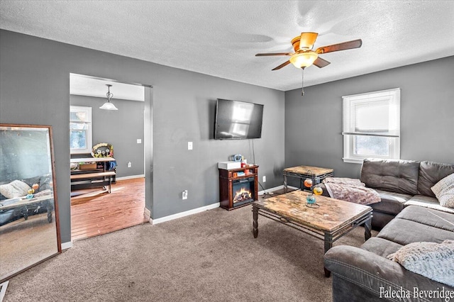 living room featuring carpet floors, a textured ceiling, and ceiling fan