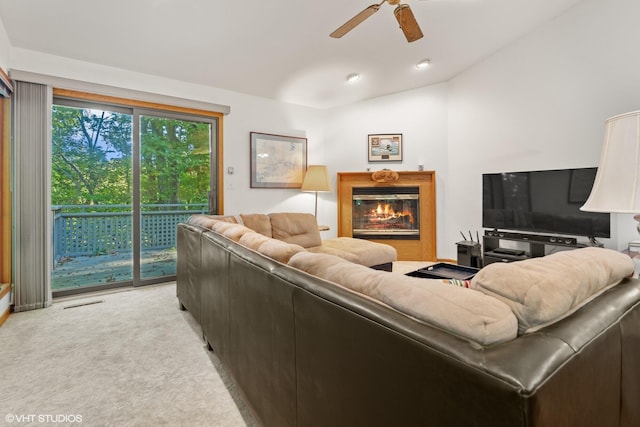 living room featuring vaulted ceiling, light carpet, and ceiling fan