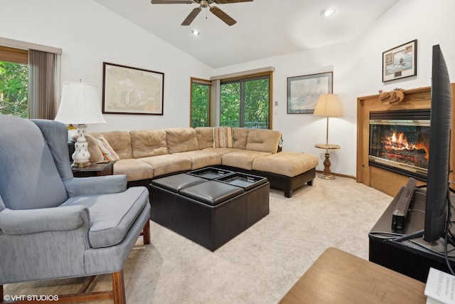 carpeted living room with ceiling fan, vaulted ceiling, and plenty of natural light