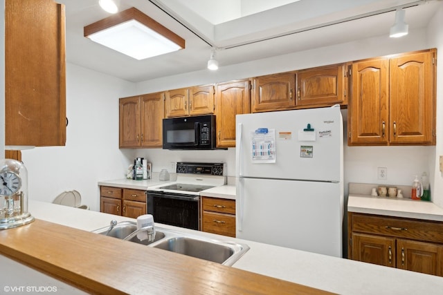 kitchen featuring sink, track lighting, and white appliances