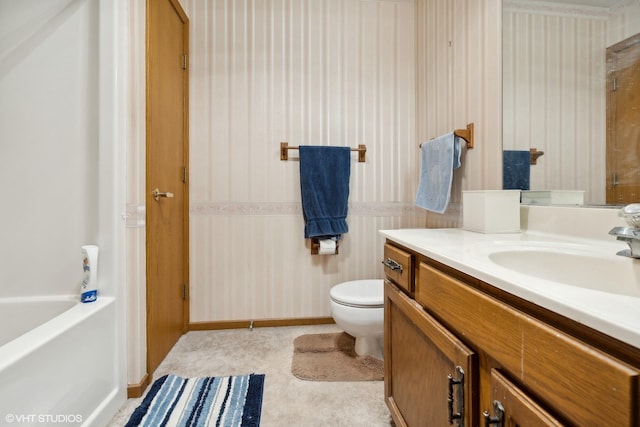 bathroom featuring toilet, vanity, and a washtub