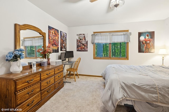 carpeted bedroom with built in desk and ceiling fan