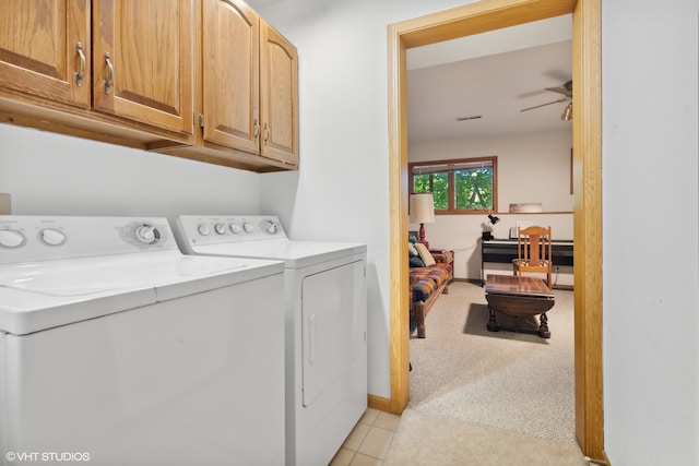 laundry area featuring ceiling fan, light carpet, washing machine and clothes dryer, and cabinets