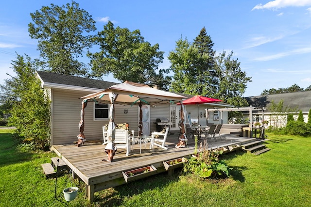 rear view of property with a gazebo, a lawn, and a deck