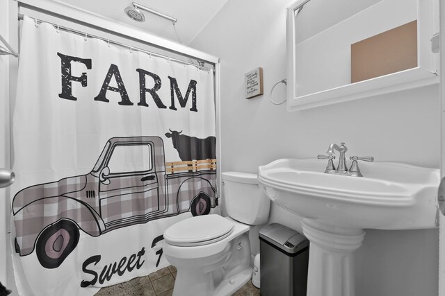 bathroom with a shower with curtain, tile patterned flooring, and toilet