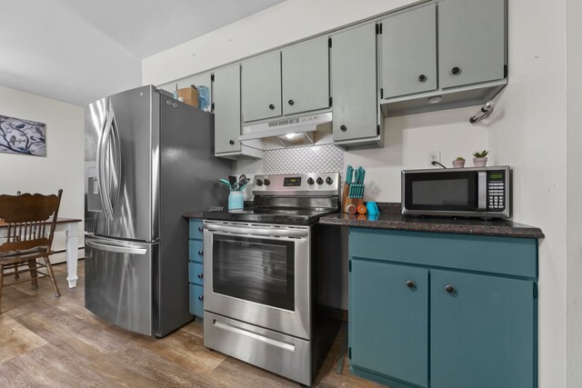 kitchen with backsplash, appliances with stainless steel finishes, and light wood-type flooring