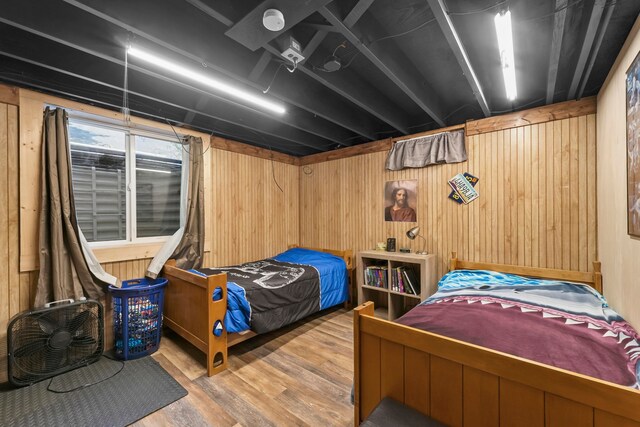 bedroom featuring wood walls and hardwood / wood-style flooring