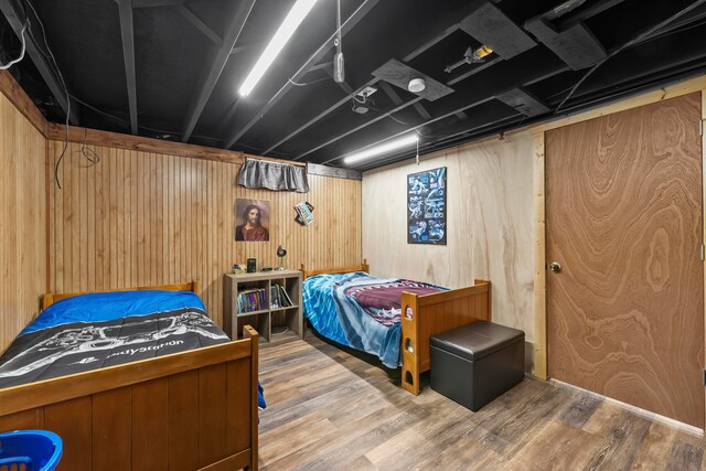 bedroom featuring wooden walls and hardwood / wood-style floors