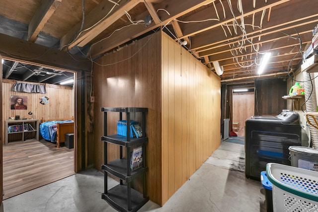 basement with separate washer and dryer and wooden walls