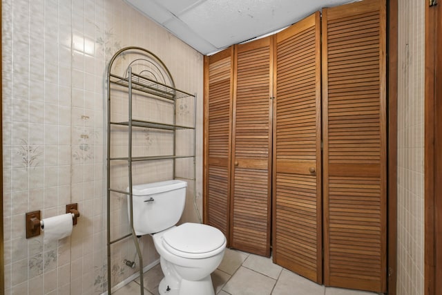 bathroom featuring tile walls, toilet, and tile patterned floors