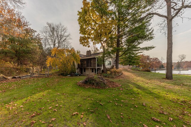 view of yard with a water view and a sunroom