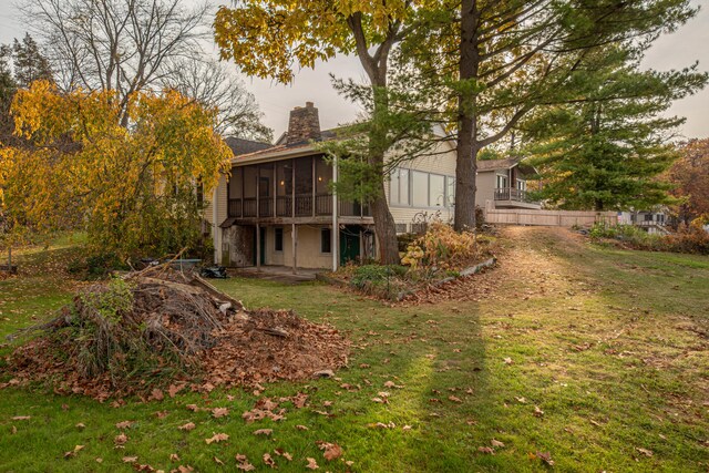 back of house with a yard and a sunroom