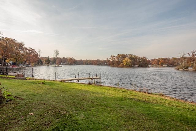 view of dock with a yard and a water view