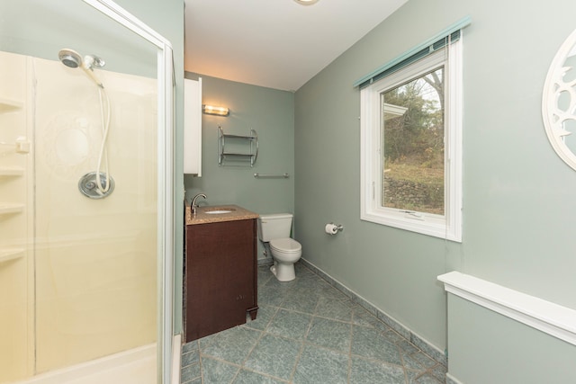 bathroom with vanity, toilet, and a shower