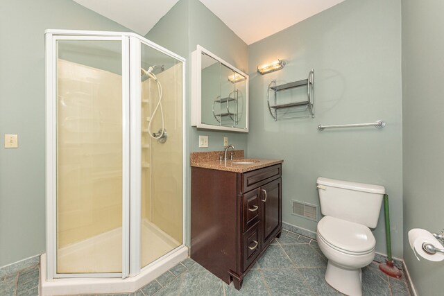 bathroom featuring toilet, walk in shower, vanity, and tile patterned flooring