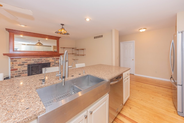 kitchen featuring white cabinetry, stainless steel appliances, sink, and light wood-type flooring