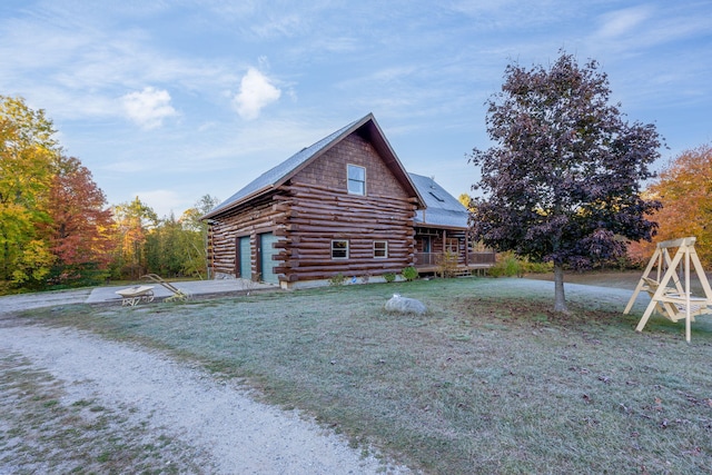 view of property exterior with a yard, a wooden deck, and a garage