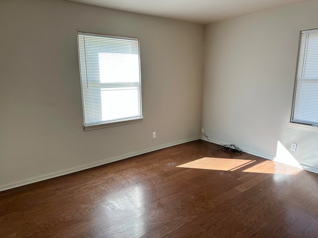 empty room with dark hardwood / wood-style flooring