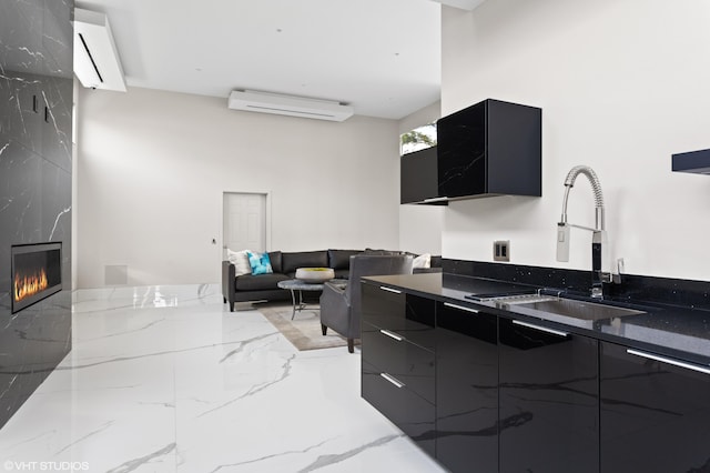 kitchen with dark stone countertops, sink, a high end fireplace, and an AC wall unit