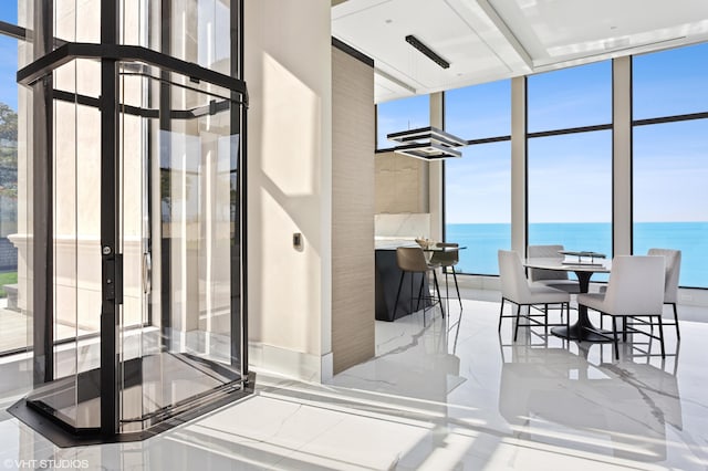 dining space with a water view and floor to ceiling windows