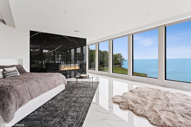 bedroom featuring expansive windows and a water view