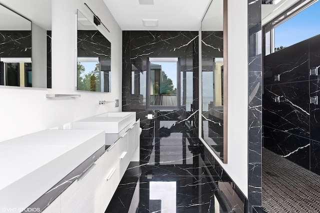 bathroom with a shower, vanity, and tile walls